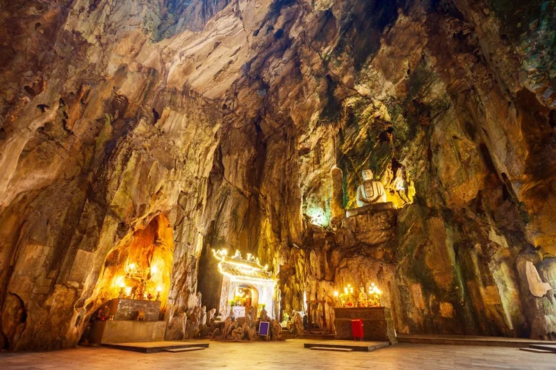 A Buddha statue and shrine altars sit inside the cavernous interior of Huyen Khong Cave at Marble Mountains. A Buddha statue and shrine altars sit inside the cavernous interior of Huyen Khong Cave at Marble Mountains.