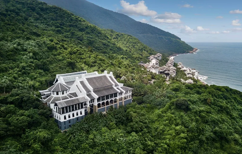 An elegant resort building sits amid green mountainside forest overlooking the coastline near Da Nang. An elegant resort building sits amid green mountainside forest overlooking the coastline near Da Nang.