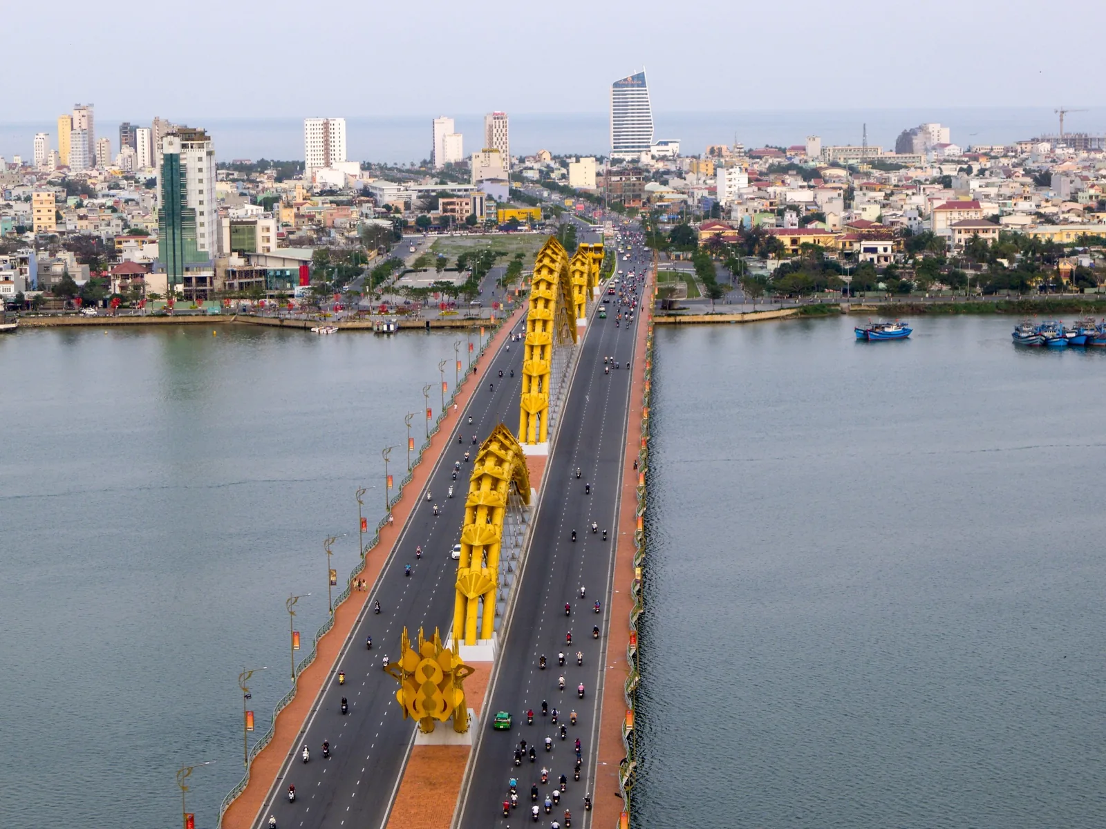 Aerial view of the Dragon Bridge with golden dragon sculptures spanning the Han River in Da Nang